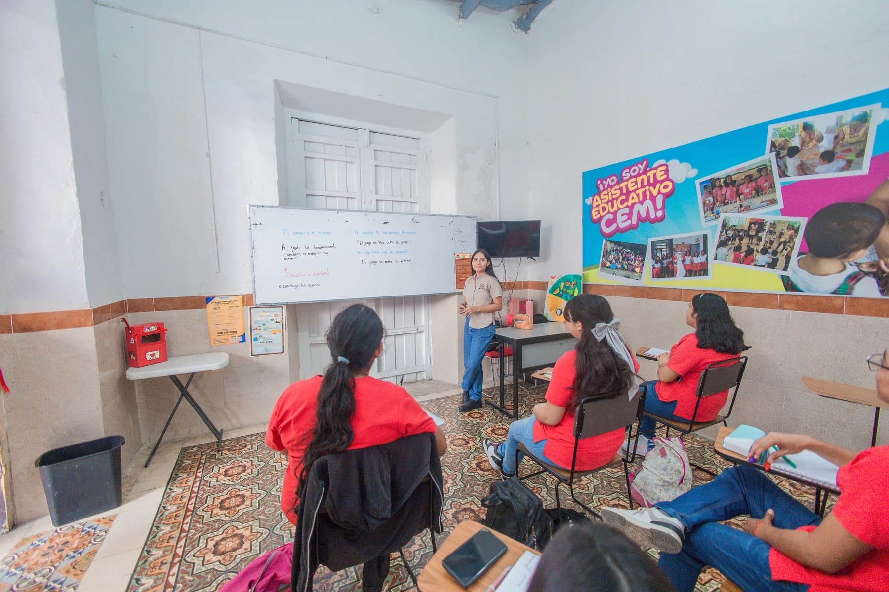 Docente acompañando a estudiantes durante una clase del CEM